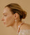 Model in profile on tan backdrop wears Estate Pearl Necklace in Pink and Palazzo Earrings