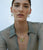 Model on blue backdrop wears gauzy top with beaded opal necklace and semiprecious charms with Birthstone Charm in Diamond