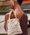 Back shot of model with purse held over her shoulder, in brown top and Casablanca Earrings.