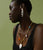 Model in profile on green backdrop wears black bodysuit with Moonlight Charm Necklace and Pearl Holiday Earrings