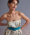 Model on grey backdrop wears strapless floral dress with Louise Belt in Teal Suede.