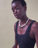 Video of model on green backdrop; she wears black tank with Martina Heart Necklace and Pacifica Pearl Collar. 