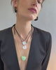 Video of model on grey backdrop in black blazer with Gemini Necklace in Mint, two Meret Necklaces, and Organic Hoops.