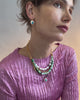 Video of model on grey backdrop in pink pleated top with Pearl Pablo Earrings in Turquoise and Vizcaya Necklace in Mint.