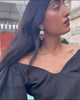 Video of model in profile wearing black top with Parade Earrings.