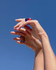Video of model's hands twisting in sky wearing Monument rings on both hands in Azure, Ochre, Jade and Terra.