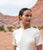 Model with desert hills and bushes in the background wears white top with Magdalena Earrings.