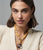 Model on grey backdrop wears cream sweater and Mood Necklace in Yellow Jade with assorted charms. 